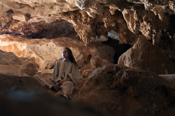Woman traveler in the Djara Cave in Egypt with impressive stalagmites and natural rock formations. ...