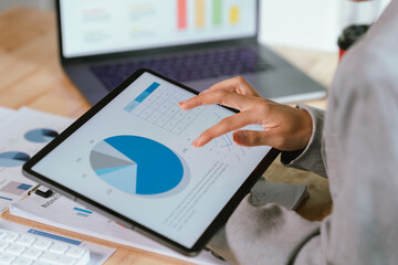 Businessman analyzing financial charts and documents at office desk, focused on planning, investment, accounting, growth strategy, and corporate success