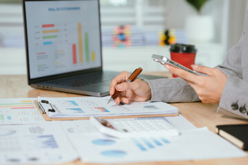 Businessman analyzing financial charts and documents at office desk, focused on planning, investment, accounting, growth strategy, and corporate success