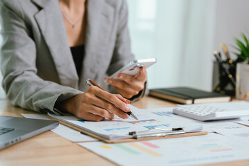 Businessman analyzing financial charts and documents at office desk, focused on planning, investment, accounting, growth strategy, and corporate success
