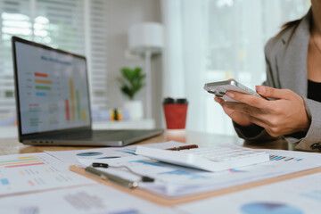 Fototapeta premium Businessman analyzing financial charts and documents at office desk, focused on planning, investment, accounting, growth strategy, and corporate success