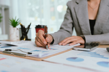 Businessman analyzing financial charts and documents at office desk, focused on planning, investment, accounting, growth strategy, and corporate success