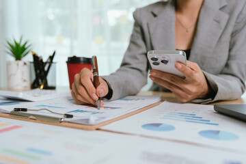 Businessman analyzing financial charts and documents at office desk, focused on planning, investment, accounting, growth strategy, and corporate success