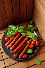 Thin smoked Polish sausages on a black plate.