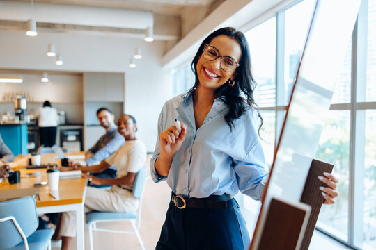 Smiling professional presenting at a meeting in an office environment
