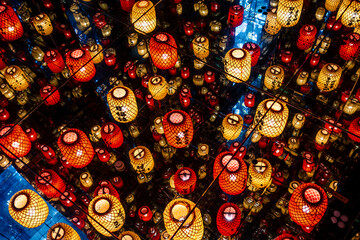 Chinese lanterns illuminated on the ceiling reflecting in the mirrors