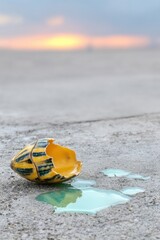 Obraz premium Broken Yellow And Green Shell With Liquid Spill At Sunset