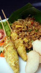 Spicy Nasi Goreng: Spicy Javanese fried rice, a culinary delight, topped with neatly sliced egg rolls. Ideal for food blogs, traditional recipes, and Southeast Asian themes