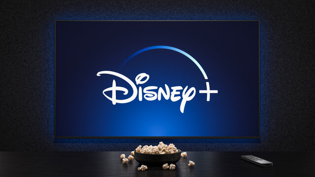 A TV showing the logo splash screen of Disney+, with a bowl of popcorn and TV remote in the foreground, render