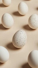 A beige background features a scattered arrangement of speckled and plain white eggs, casting soft shadows