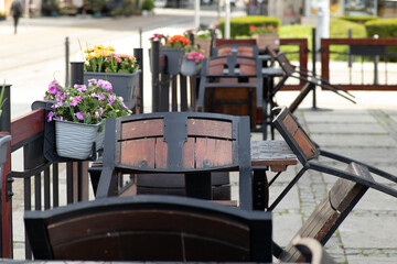 Outdoor cafe terrace with overturned wooden chairs and flowerpots