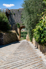 A scenic corner in Monteriggioni, Tuscany, with medieval tower ruins and rustic stone buildings