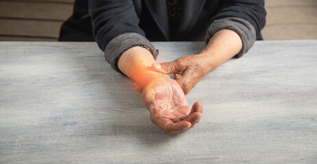 Caucasian elderly woman suffering from pain in hand.