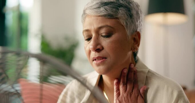 Sweating, woman and fan for heat in home, breathe or symptoms of menopause or hot flash in lounge. House, warm feeling and mature person with hormonal fluctuations, vasomotor and decline of estrogen