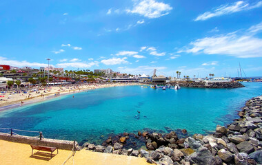 View of Playa La Pinta in Puerto Colon small beach with volcanic sand,calm waves and transparent water in Tenerife,Canary islands,Spain.