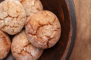 Ginger snap cookies in wooden brown bowl. Cracked crispy texture. Top view