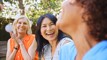 Close Up Of Smiling Mature Female Friends Socializing In Backyard Together