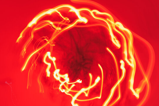 Vibrant red light trails create hypnotic patterns in dynamic motion