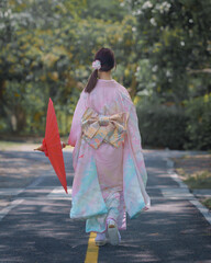Pretty young Asian Japanese woman in Traditional Yukata Dress. A young Asian girl is wearing a...