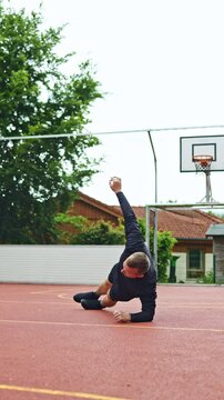 Young athletic man warming up before training outdoors. Man in sports shorts and raglan doing sports. Healthy lifestyle