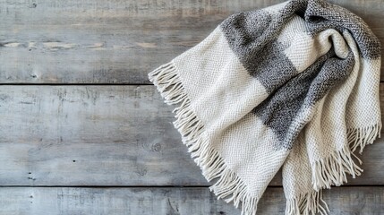 Thick handwoven shawl in shades of gray and cream with subtle fringe detailing spread out on a...