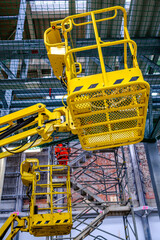 Construction equipment is positioned in a courtyard with safety cones and tools visible, ideal for maintenance tasks in an urban environment