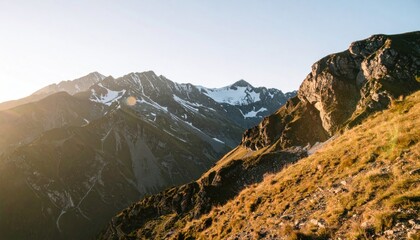 Majestic mountain range, grassy foreground, snow-capped peaks, sunny sky