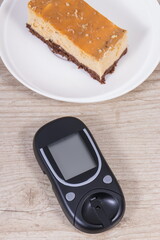 Glucometer for measuring sugar level and sweet cheesecake. Nutrition during diabetes