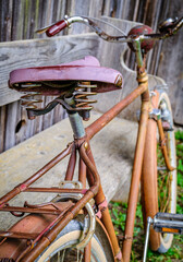 Vintage blue bicycle leaning against a colorful wall in bright sunlight during afternoon hours in an urban setting