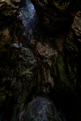 The Grotte di Labante waterfall flows over moss-covered rocks, creating a unique natural formation in the Italian Apennines