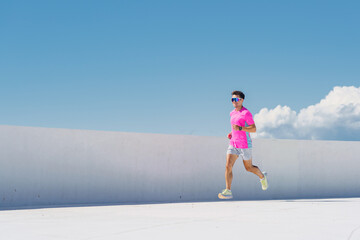 Brightly Dressed Runner Enjoys Sunny Day at the Rooftop Track While Clouds Float Gently in the...