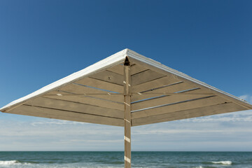 beach umbrella made of wood on the sea in sunny weather