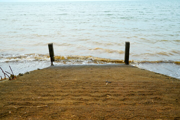 a mossy path juts out into the choppy sea.