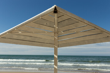 beach umbrella made of wood on the sea in sunny weather