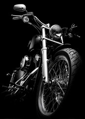 Shiny black motorcycle stands in the dark. Chrome parts reflect the light strongly.