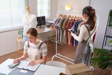 Asian Women Managing Online Fashion Store Business Stocktaking Checking Orders Using Calculator and...