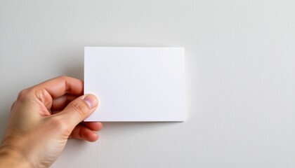 hand placing a blank tent card mockup on light background, position subject on the left with copy space on the right for photos.
