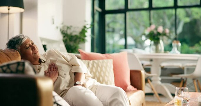 Senior woman, chest pain and heart attack on sofa with medical emergency, cardiac arrest and crisis. Healthcare, old person and breathing issue in home with cardiovascular disease and hypertension