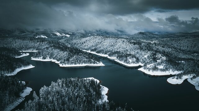 Aerial view of a serene snow-covered forest and winding river
