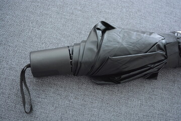 Things are objects of constant use. A beautiful beige, gray umbrella with a black lining and a...