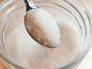 Sugar in a jar. Sugar consumption, white granulated sugar. Calories of sugar.