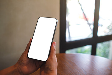 Mockup image of a woman holding mobile phone with blank screen