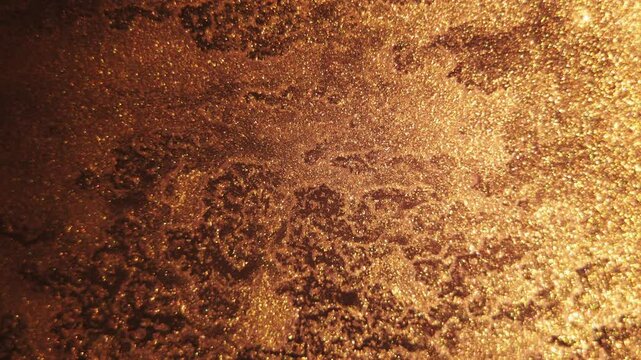 Liquid gold flowing in smooth waves, creating a beautiful abstract metallic background with elegant golden swirls and rich texture.