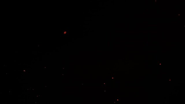 Sparks particles fly in slow motion in the air lingering slowly. Dust Particles Background Bokeh Lights Background on Black Background 4k Footage
