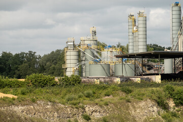 Obraz premium Industrial plant processing materials with storage tanks and silos