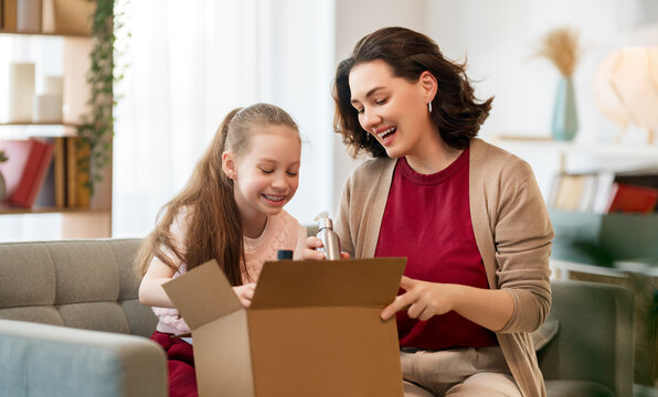 Mother and daughter are unpacking cardboard