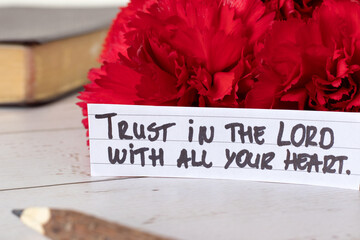 Trust in the LORD with all your heart, handwritten quote with holy bible book. Faith in God Jesus Christ, biblical concept.