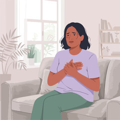 An anxious woman holding her chest sitting on the sofa.