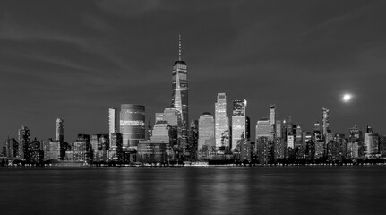 new york city downtown manhattan skyline at sunset blue hour long exposure skyscraper buildings reflecting sunlight with moon rising in background nyc travel tourism usa photo photography