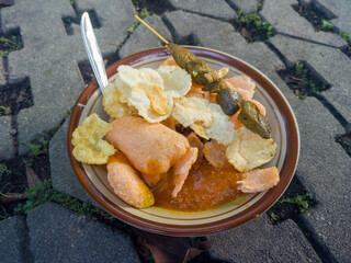 Chicken porridge, a traditional Indonesian food consisting of white rice porridge, shredded chicken, fried soybeans, crackers, and spring onions.